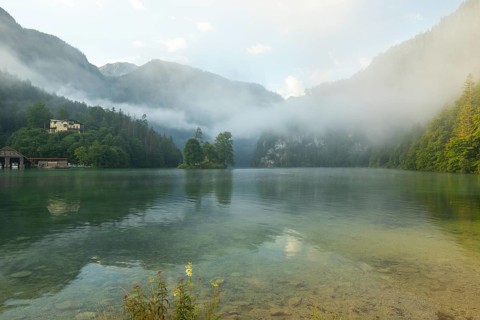 Mystical morning at Königssee in Schönau with boathouses and Christlieger. Sunrise and beautiful
