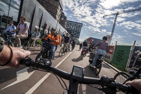 Ride your bike on the central cycle path on Lange Viestraat, Vredenburg, in the city centre of