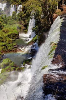 View from a cliff of cascading waterfalls and rainbow in the river below, The Iguazu Falls between