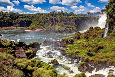 Rushing river with rapids and waterfalls under a blue sky, The Iguazu Falls between Argentina and