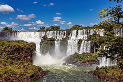 Impressive waterfalls with cliffs and spray under a blue sky, The Iguazu Falls between Argentina