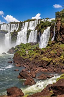Close-up of waterfalls cascading over rocks in dense green growth, The Iguazu Falls between