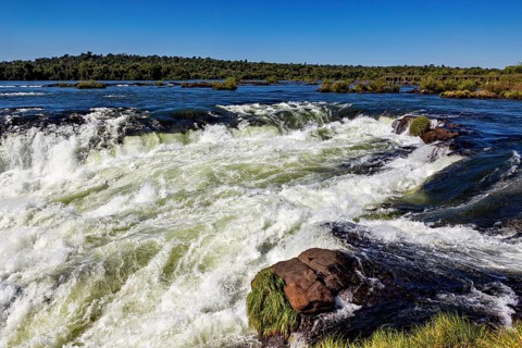 Slightly turbulent river with small rapids, the waterfalls of the Iguazu between Argentina and