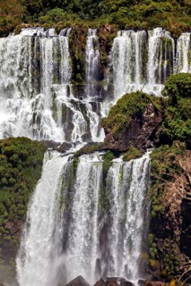 Stepped waterfall with dense vegetation on the rocks, powerful flow, The Iguazu Falls between