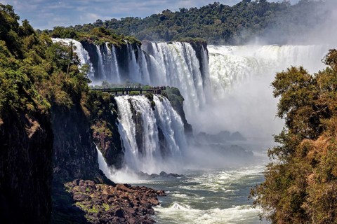 Majestic waterfalls with observation bridge, large river and lush forest backdrop, The Iguazu Falls