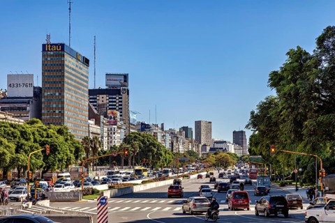 A busy urban scene with skyscrapers in the background and cars on the street, The skyline of the