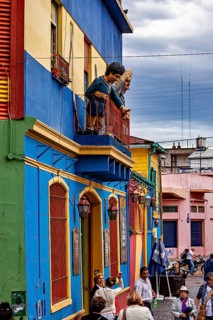 Lively street with balcony sculptures and colourful houses in La Boca, the colourful city and tango
