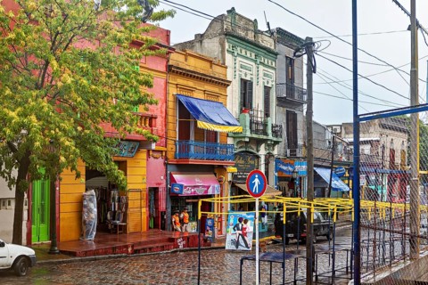 Lively street with colourful buildings and wet cobblestones on a cloudy day, The colourful city and