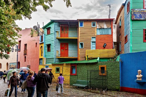 Colourful buildings with people on a cobbled street, lively and creative atmosphere, The colourful