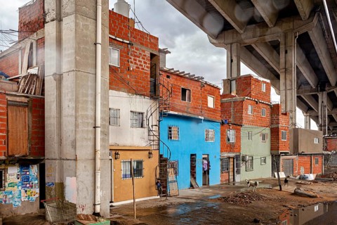 Brick houses under a bridge with a dull sky in an urban environment, The colourful city and tango