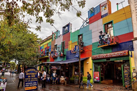 A colourful façade full of artists and shops attracts people despite the rain clouds, The colourful