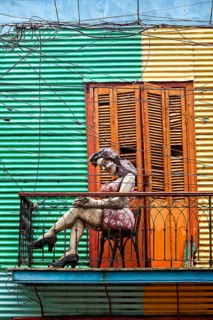 Colourful façade with sculpture of a woman on a small balcony, The colourful city and tango