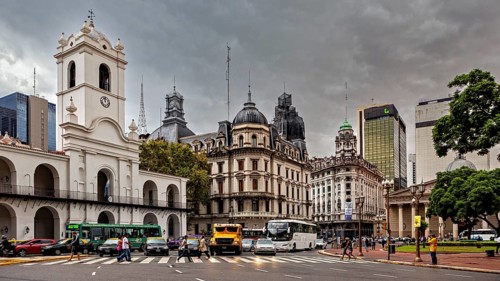 Different architectural styles meet under a cloudy sky in an urban space, Historic buildings in the