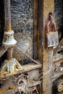 Detail of an old dilapidated door with cobwebs and a rusty lock, La Recoleta cemetery in Buenos