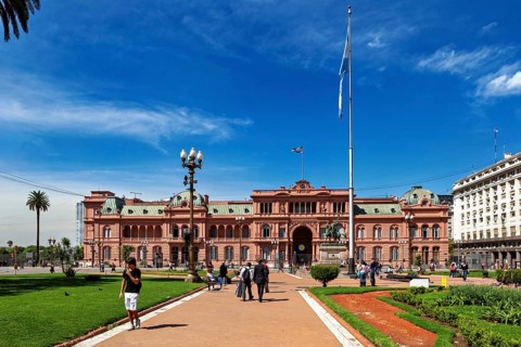 Historic building with surrounding gardens and flag, sunny day in Buenos Aires, The presidential