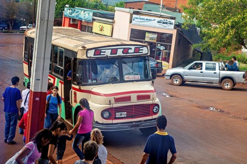A bus stops in a suburban area, surrounded by people and vehicles, An old Mercedes bus in Argentina
