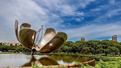 Architectural metal flower in a park with urban backdrop and blue sky, The lotus flower in Buenos