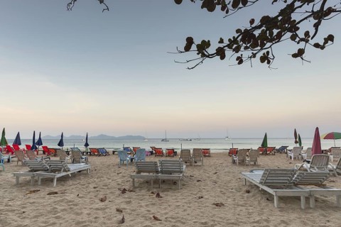 Abandoned deckchairs and parasol after sunset at Charlie Beach, Koh Mook Island, Andaman Sea,