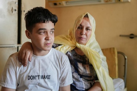Wounded individuals receiving treatment at a hospital after being evacuated with difficulty from