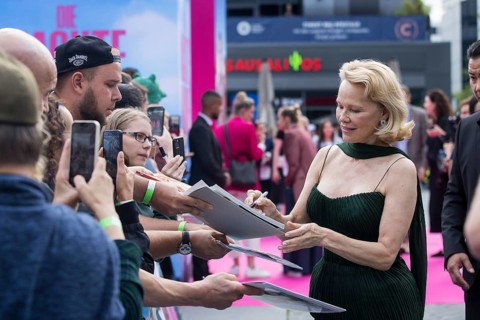 Pamela Anderson signs autographs in front of the film premiere of The Naked Gun at UCI Luxe East