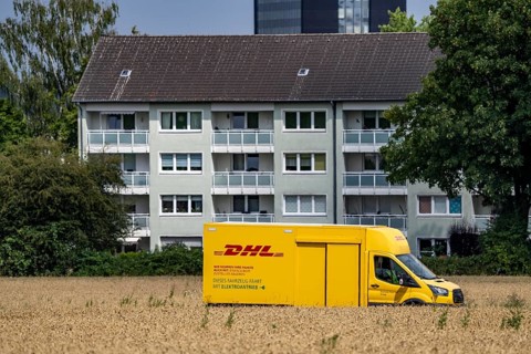DHL parcel van, electric vehicle, on the way to a customer, rural, driving along a dirt track