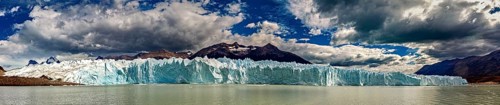 Large-scale panorama of a distant glacier with draped clouds and mountains, The glacier of Perito