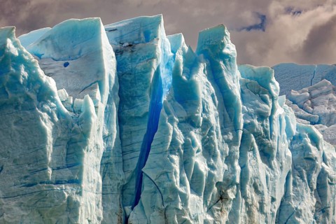 Majestic glacier wall under a cloudy sky in different shades of blue, The blue ice of the Perito