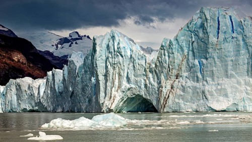 Majestic glacier in the water with dramatic clouds and mountains in the background, The Perito