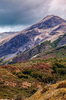 Imposing mountain with steep slopes and dense vegetation under a cloudy sky, the Patagonian