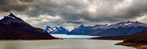 Vast, dramatic landscape in a panoramic format with glaciers and clouds over the horizon, The