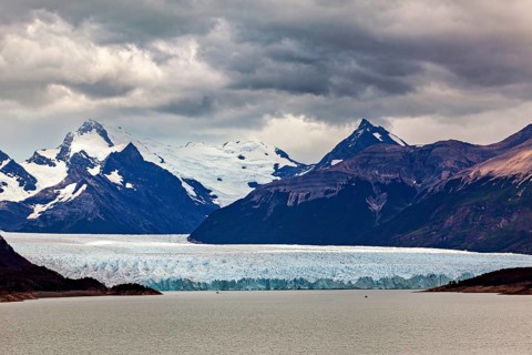 Vast landscape with an impressive glacier and snow-covered mountains under a cloudy sky, The Perito