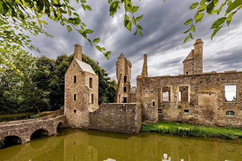 Medieval ruins under a dramatic sky with nature in the foreground, Gratot Castle in Normandy,