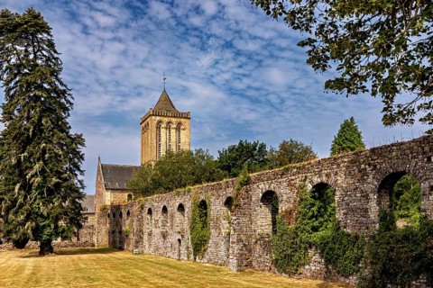 A church tower and a historic stone wall surrounded by trees in summer weather, The Abbey de La