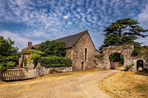 Spacious property with a stone building and archway, surrounded by a rural setting, The Abbey de La