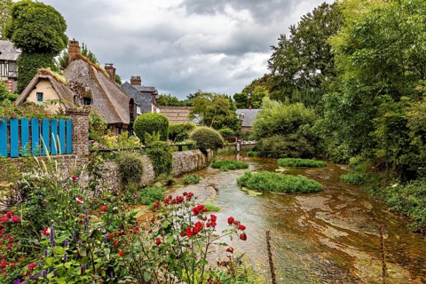 Picturesque landscape with a river and flowering gardens in a village, the historic mill village of