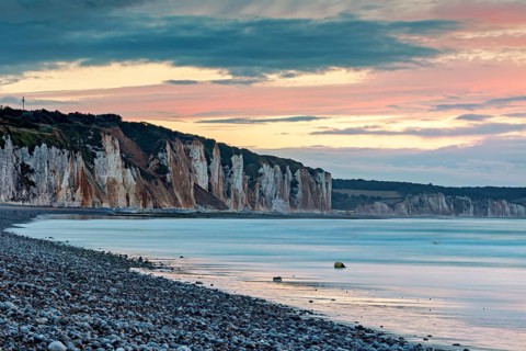 Dramatic cliff landscape with gentle sea coast at sunset with atmospheric sky, The cliffs near