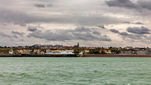 Coastal town with cliffs and a church, under a cloudy sky, The coast of Dieppe in Normandy, France