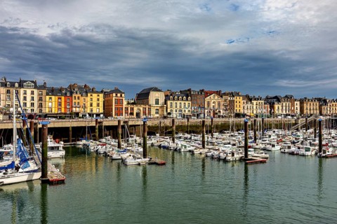 Historic buildings line a harbour full of boats under a cloudy sky, The harbour of Dieppe in