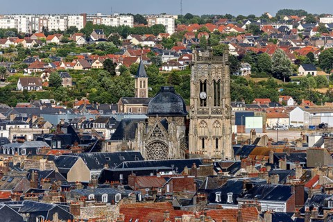 Town view with striking church tower surrounded by old tiled roof houses and green surroundings,