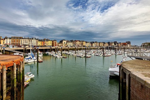 View of a harbour with many boats and historic buildings under a dramatic sky, The harbour of