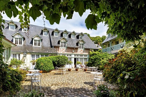 Inviting courtyard with cobblestones, garden furniture and a charming half-timbered house, The