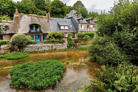 Picturesque village on a river with half-timbered houses and lush nature, the historic mill village