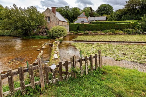 Picturesque landscape with river, old stone bridge and traditional houses in the countryside, the