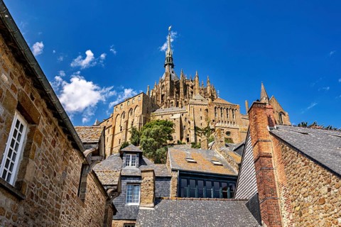 Sublime castle with Gothic towers, rising into the sky above the roofs of historic buildings, Mont
