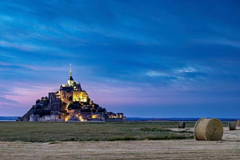 Mont Saint-Michel at dusk, illuminated with straw bales in the foreground, Mont Saint Michel in