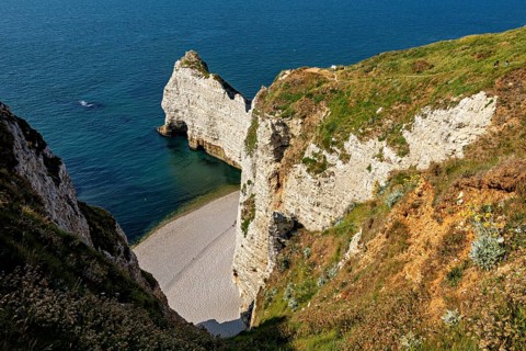 Steep rocks and cliffs with a small hidden beach by the turquoise blue sea, The cliffs and