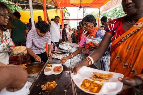 Devotees throng to have food as they arrives to visit Kamakhya Temple during Ambubachi Mela, in