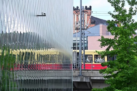 A suburban railway is reflected in the façade of the Futurium in Berlin-Mitte