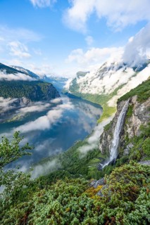Gjerdefossen waterfall, at Ørnesvingen viewpoint, atmospheric clouds over the fjord in the morning