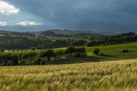 Dramatic cloudy sky with approaching storm and last rays of sunshine, Frankenhain, dark cloud wall,